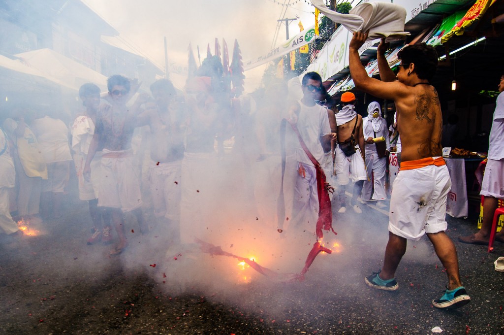 Фотография взрывающейся связки петард в группе людей. Вегетарианский фестиваль на Пхукете.