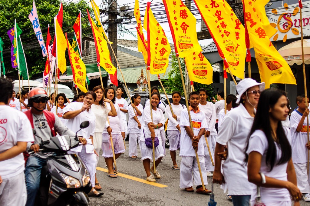 Люди в белом с флагами во время празднования вегетарианского фестиваля на Пхукете.